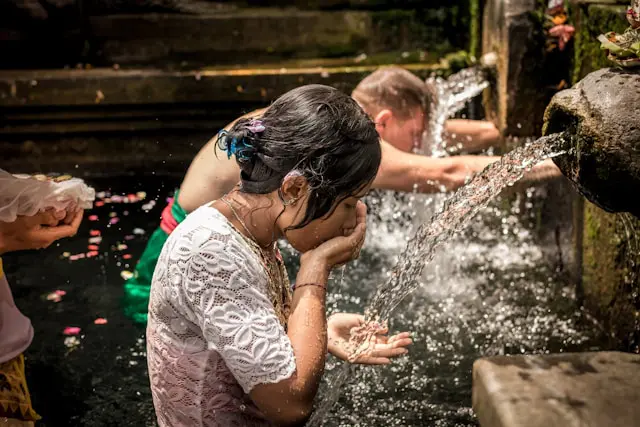 People drinking water from a natural spring, emphasizing the importance of staying hydrated for health and well-being.