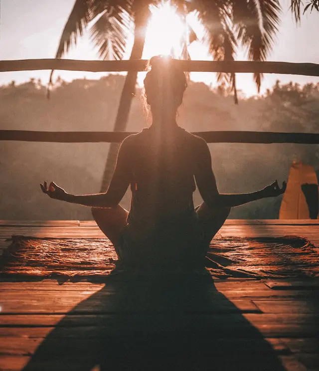 A serene image of a person meditating in a tranquil outdoor setting, in a forest