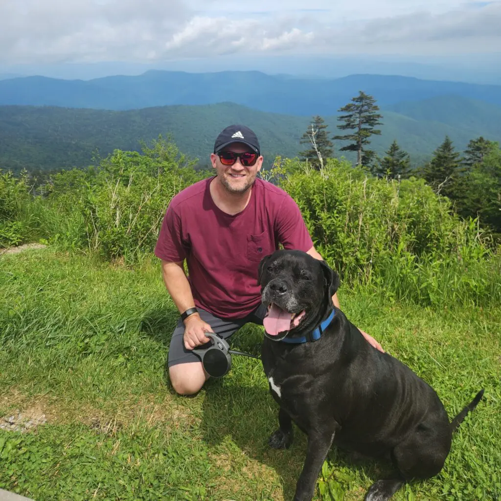 Rob Bruhn, Bananomad founder, posing with his dog, Taz, in front of the Smoky Mountains.