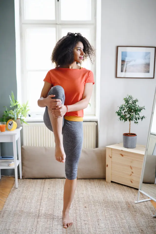 Young woman performing a yoga pose in her living room