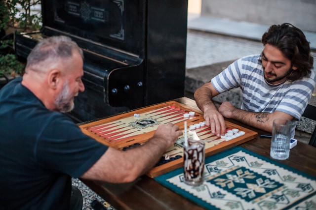 Two men enjoying a board game together, smiling and interacting.