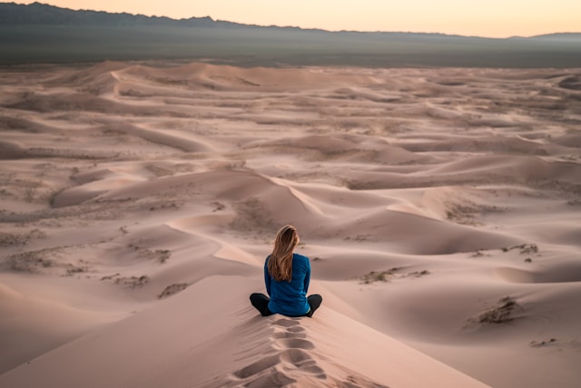 woman sitting on the ultimate meditation cushion, a sand field