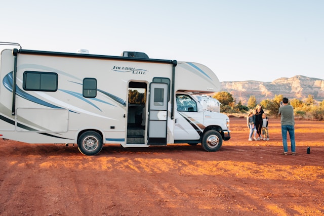 RV newbies posing for a picture, excited to hit the road after acquiring all of their must-have items for a safe and enjoyable trip