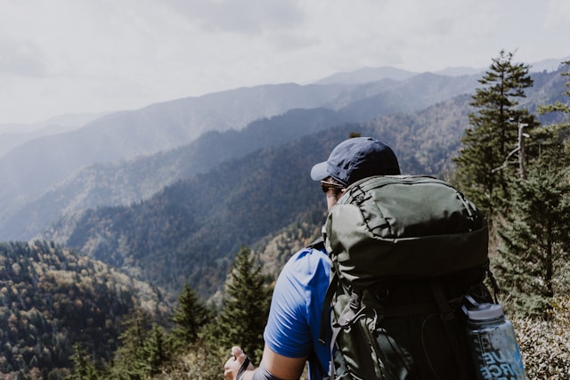 Backpacker enjoying a mountain view during a hike, inspired by books about backpacking