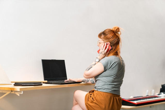 A woman sitting at her desk in a modern office setting, demonstrating effective workspace organization strategies.