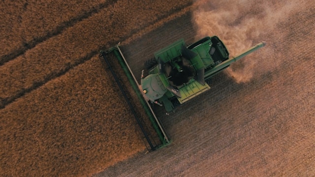 Aerial view of a harvesting machine working in a field.