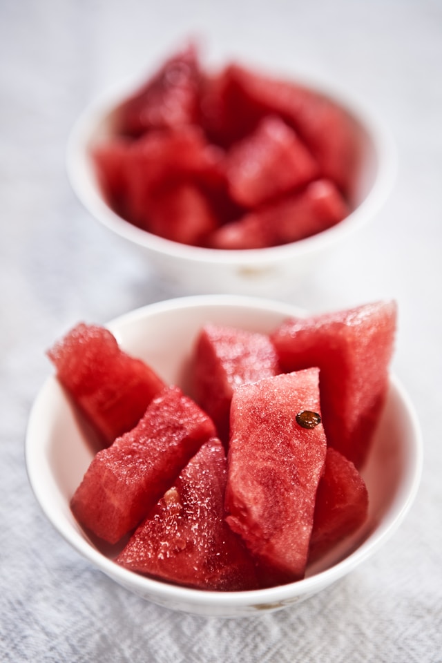 Close-up of two bowls filled with fresh watermelon cubes.