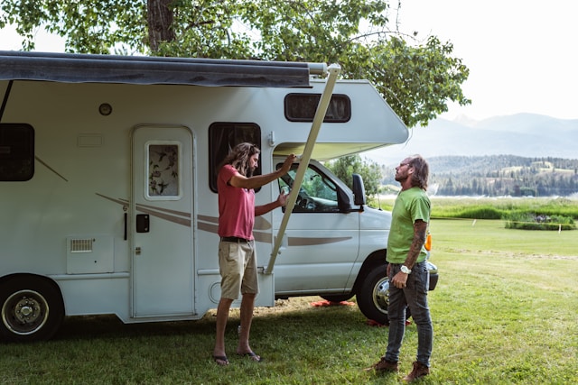 Two RV owners sharing maintenance tips on an RV awning