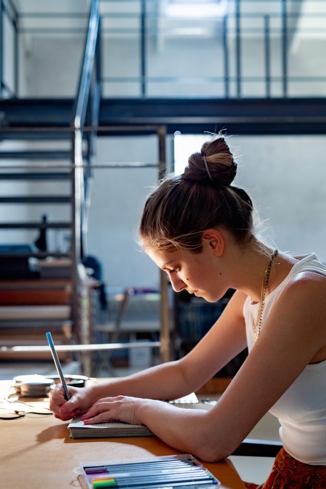 Woman sitting at a desk, focused on journaling