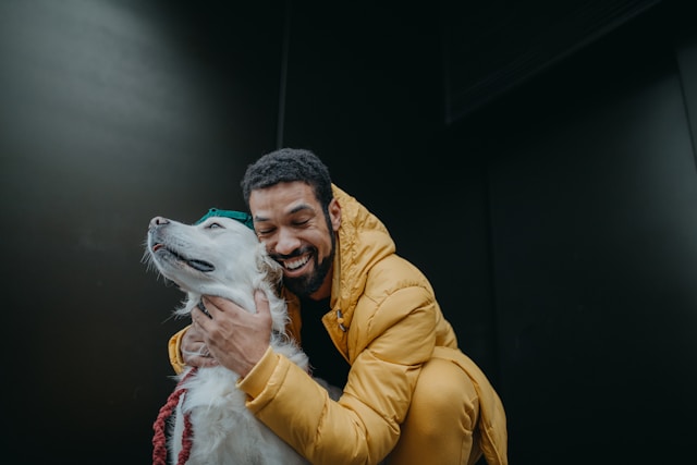 A happy man hugging his emotional support dog and smiling