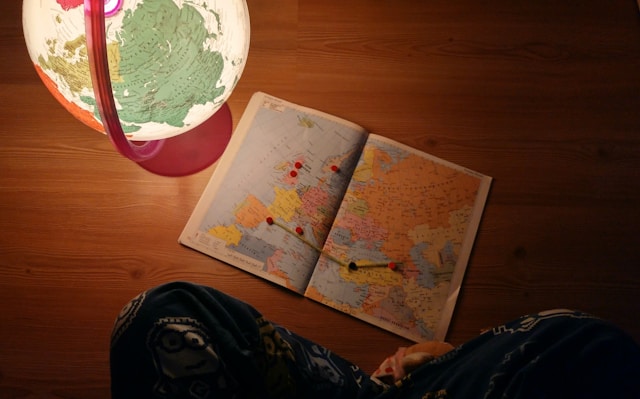 Cozy nighttime travel planning with a globe and map