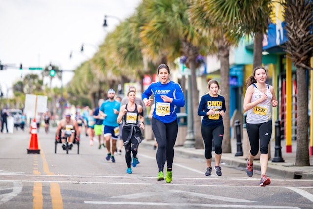 A group of runners competing in a marathon along a coastal street, with the vibrant scene emphasizing endurance and community participation.