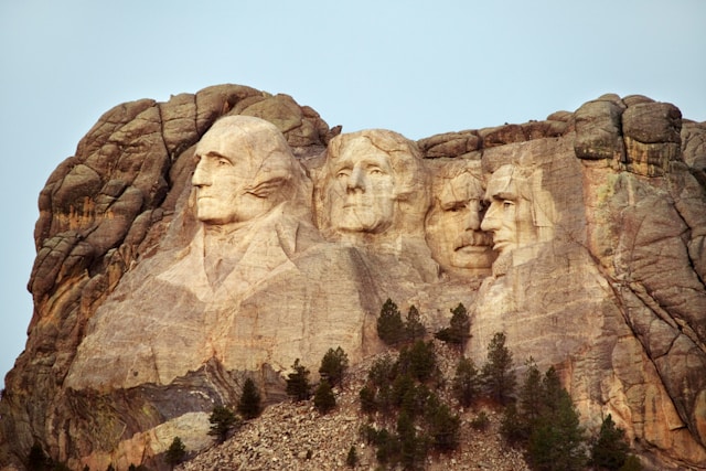 Detailed view of Mount Rushmore National Memorial depicting the sculpted faces of four U.S. presidents set against a clear sky.