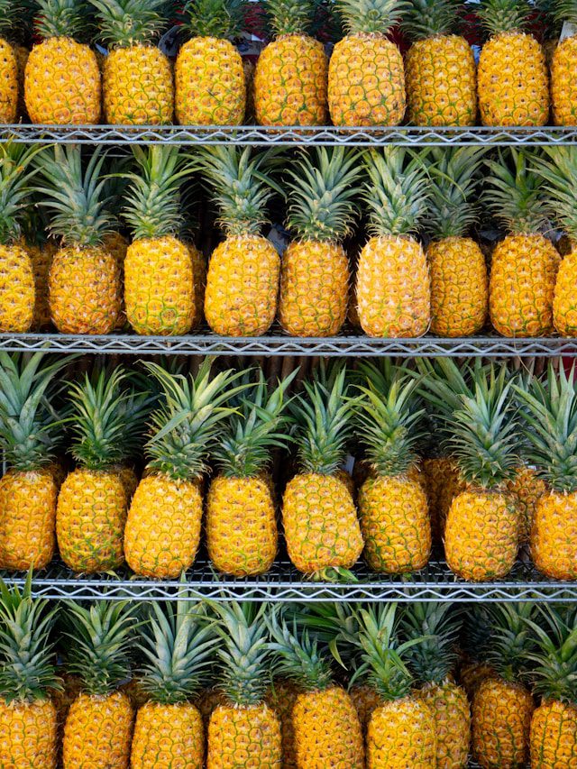 Stacked pineapples on display at a fresh market