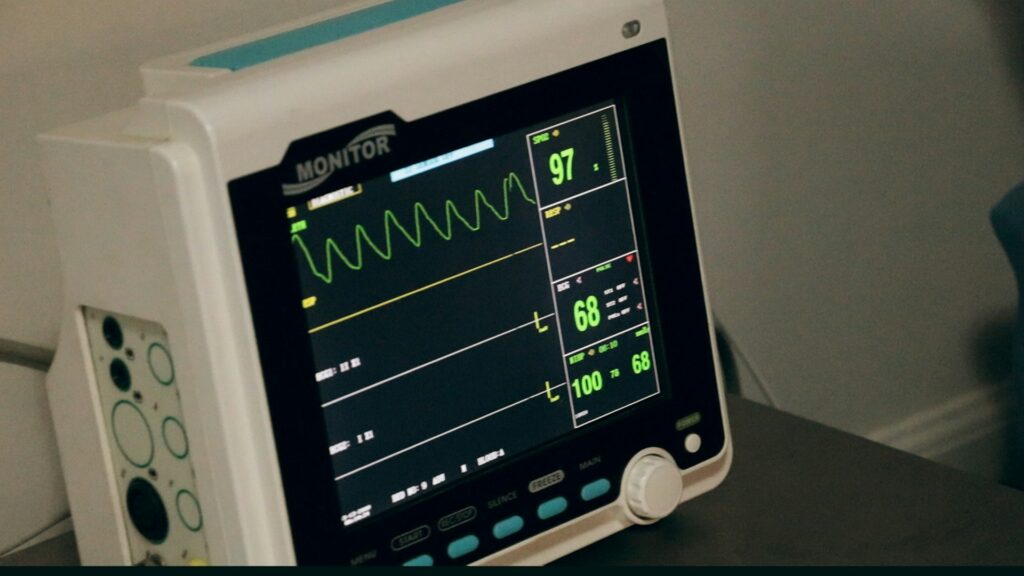 Hospital heart monitor screen showing vital signs including heart rate and oxygen saturation levels.