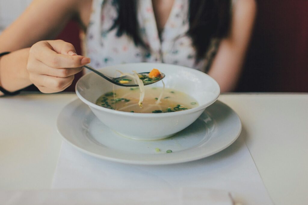 Young woman eating pho at a restaurant