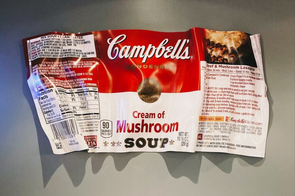 A crumpled label of Campbell's Cream of Mushroom Soup with visible nutrition facts and cooking instructions.