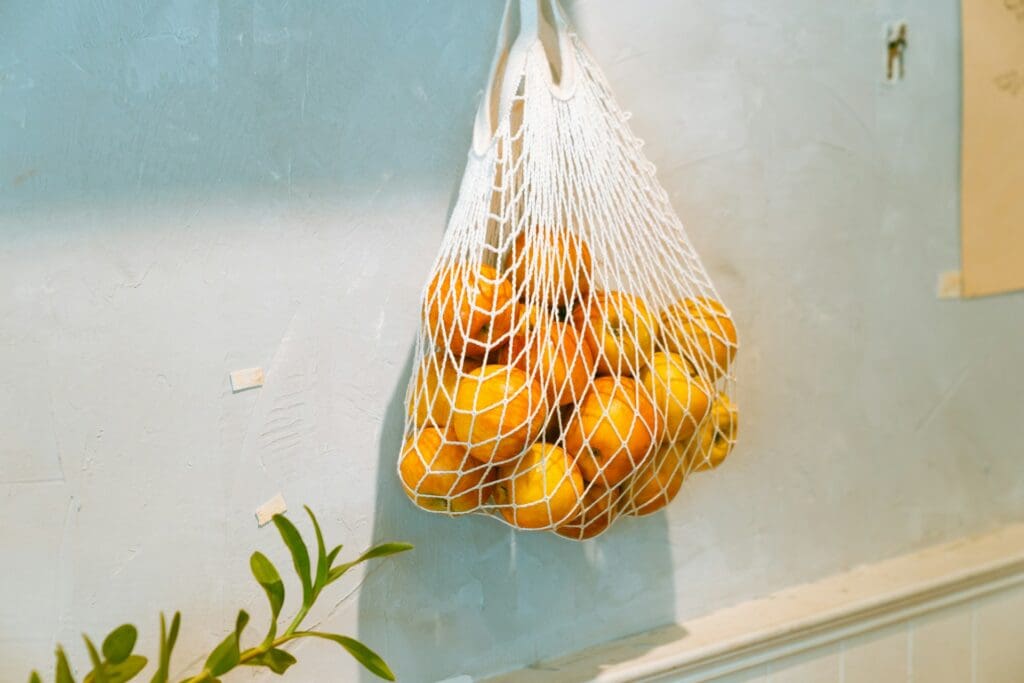 Oranges in a fruit hammock on the wall, a low-cost, space-saving solution for minimalist nomads